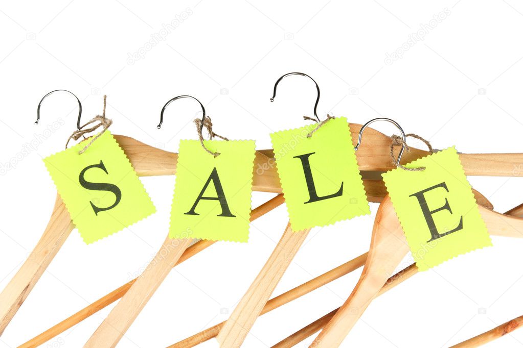 Coat hangers with sale tag on white background close-up