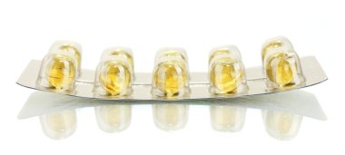Balık yağı beyaz yakın çekim izole sarı parçaları ile blister