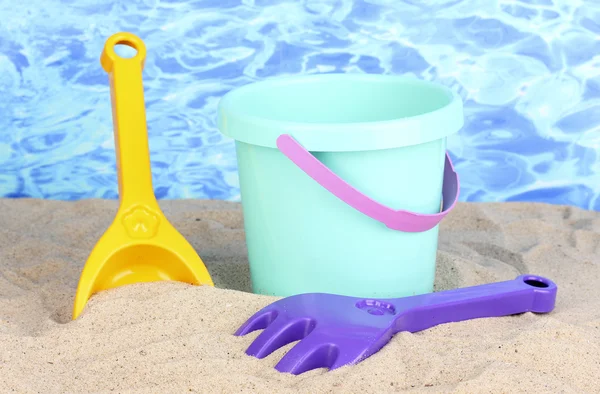Dětské plážové hračky na písku na pozadí vody — Stock fotografie