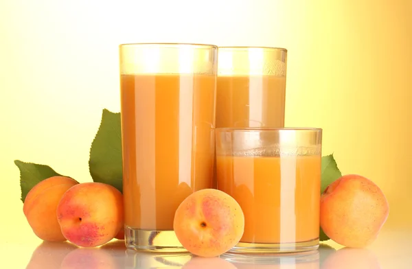 Стаканы абрикосового сока на желтом фоне — стоковое фото