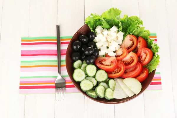 Tasty Greek salad on white wooden background — Stock Photo, Image