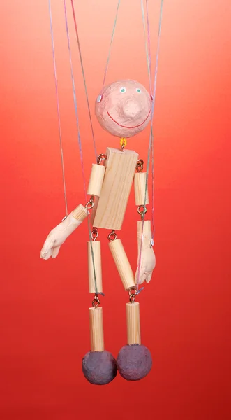 Wooden puppet on red background — Stock Photo, Image