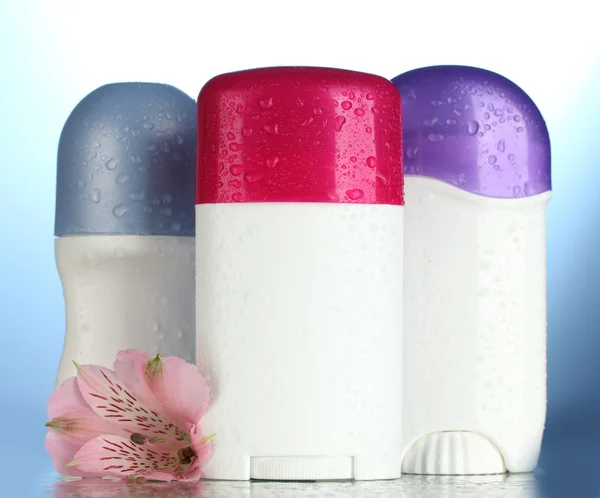 파란색 배경에 꽃과 deodorants — 스톡 사진