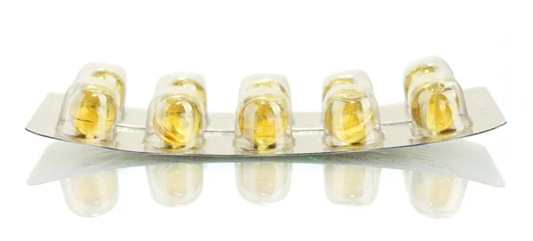 Blister med gula pellets av fiskolja isolerad på vit närbild — Stockfoto