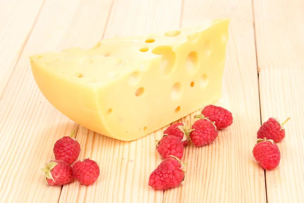 Smakelijke kaas en bessen op houten achtergrond — Stockfoto
