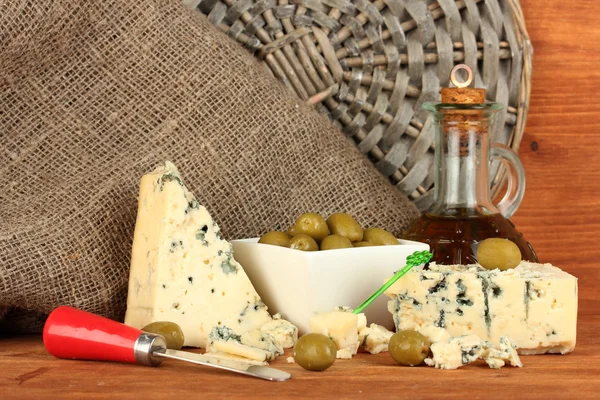 Compoziția brânzei albastre și a măslinelor într-un castron pe fundalul din lemn aproape — Fotografie, imagine de stoc