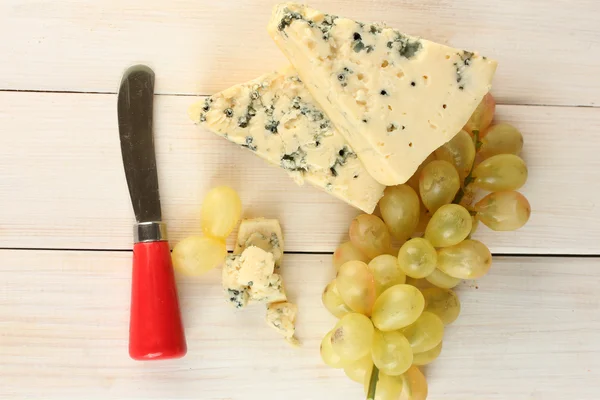 チーズのカビと白の木製の背景のクローズ アップのブドウ — ストック写真