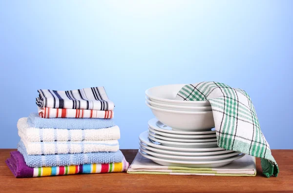 Toallas de cocina con platos sobre fondo azul primer plano — Foto de Stock