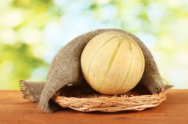 Słodki melon na maty wiklinowe na zielone tło zbliżenie — Zdjęcie stockowe
