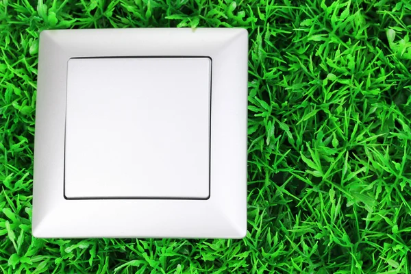 Yeşil çimenlerin üzerinde modern ışık anahtarı — Stok fotoğraf