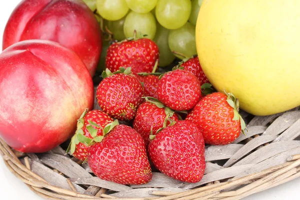 Reife süße Früchte und Beeren auf Weidenmatte in Nahaufnahme — Stockfoto