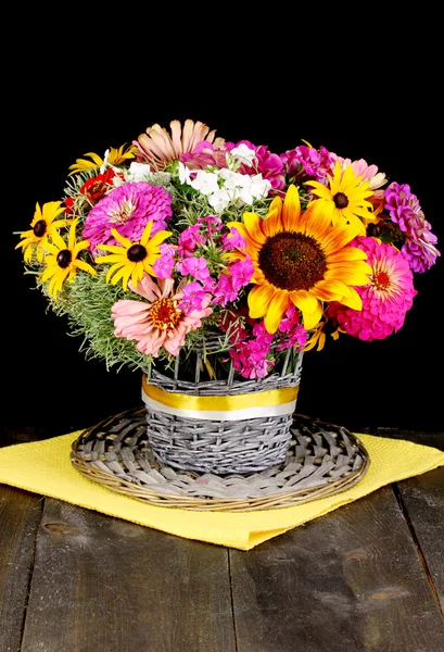 Bellissimo bouquet di fiori luminosi su tavolo di legno su sfondo nero — Foto Stock