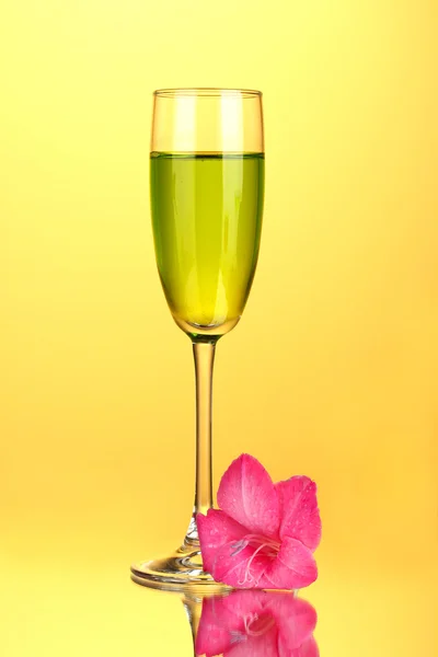Glas med cocktail och gladiolus bud på gul bakgrund närbild — Stockfoto