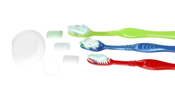 Zubní kartáčky, zubní nit a žvýkačky izolované na bílém — Stock fotografie