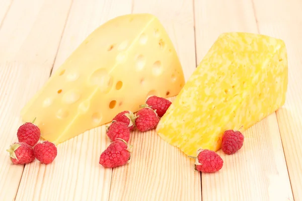 Smakelijke kaas en bessen op houten achtergrond — Stockfoto