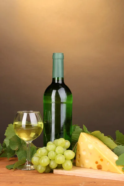 Μπουκάλι κρασιού με γυαλί και τυρί στο ξύλινο τραπέζι για καφέ φόντο — Φωτογραφία Αρχείου