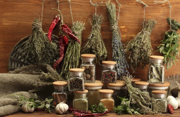 Gedroogde kruiden, specerijen en en peper, op houten achtergrond — Stockfoto