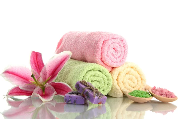 Handdoeken met mooie roze lily, aroma-olie en zee zout geïsoleerd op wit — Stockfoto