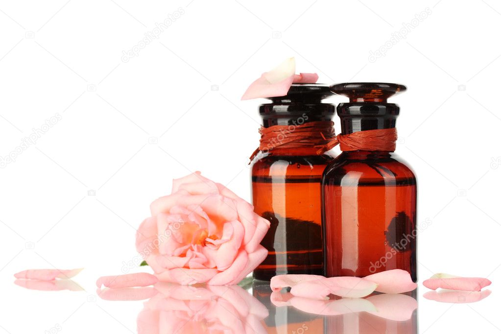 Bottles of oil and rose isolated on white