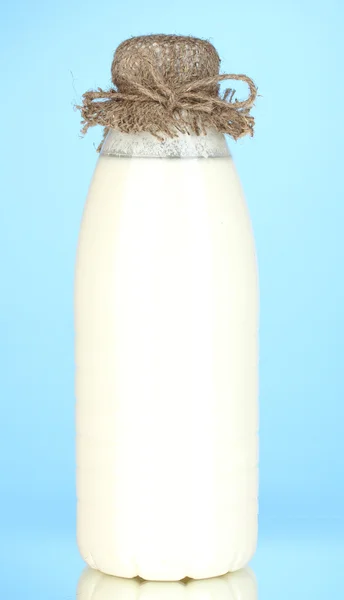 Пляшка молока на синьому фоні крупним планом — стокове фото