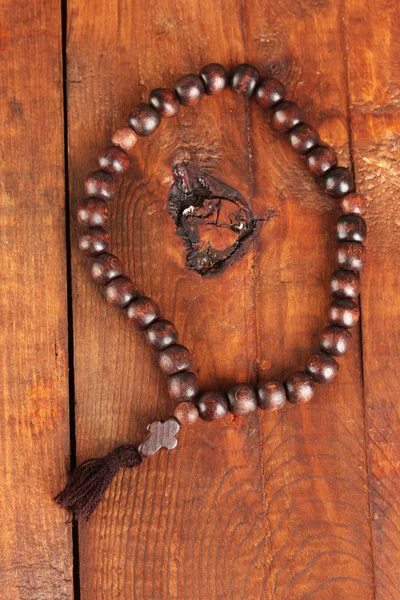 Las cuentas De madera del rosario sobre el fondo de madera el primer plano —  Fotos de Stock
