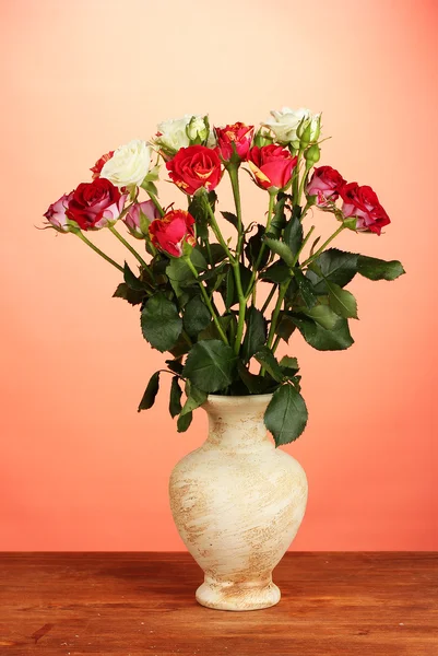 Beautiful roses in vase on red background close-up — Stock Photo, Image