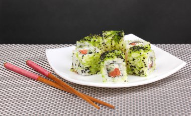 lezzetli rulo ile chopsticks gri mat gri arka plan üzerinde beyaz tabakta servis