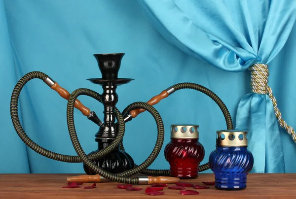 Hookah on a wooden table on a background of blue curtain close-up — Stock Photo, Image