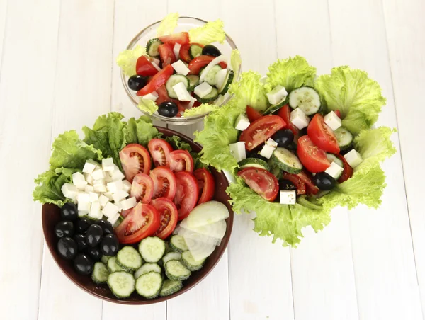 Beyaz ahşap zemin üzerinde üç leziz Yunan salatası — Stok fotoğraf