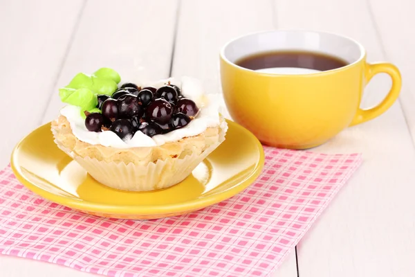 Süße Torte mit Tee auf hölzernem Hintergrund — Stockfoto