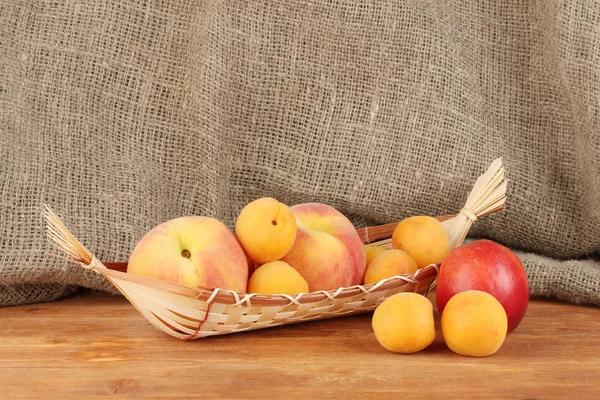 Dojrzałych owoców w koszu na płótnie tło zbliżenie — Zdjęcie stockowe