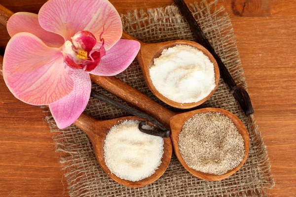 Vanilkové lusky s vanilkou a vanilkový cukr v vařečky na detail dřevěné pozadí — Stock fotografie