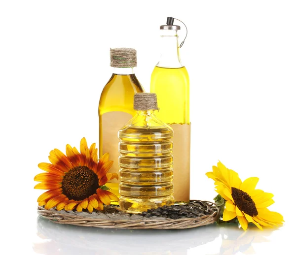 Oil in bottles, sunflowers and seeds isolated on white — Stock Photo, Image
