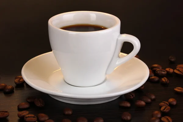 Kopje koffie op houten tafel op bruine achtergrond — Stockfoto