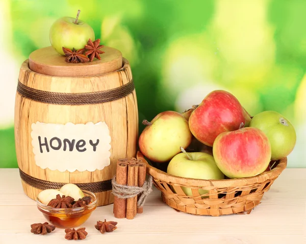 Honey and apples with cinnamon on wooden table on natural background — Stock Photo, Image