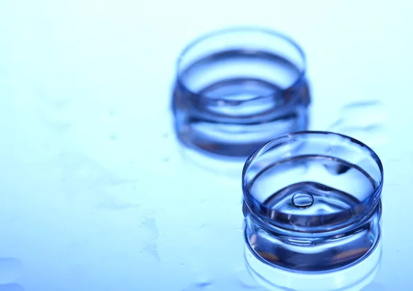 Kontaktlinse mit Tropfen auf blauem Hintergrund — Stockfoto