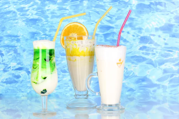 Delicious milk shakes with fruit on blue sea background — Stok Foto