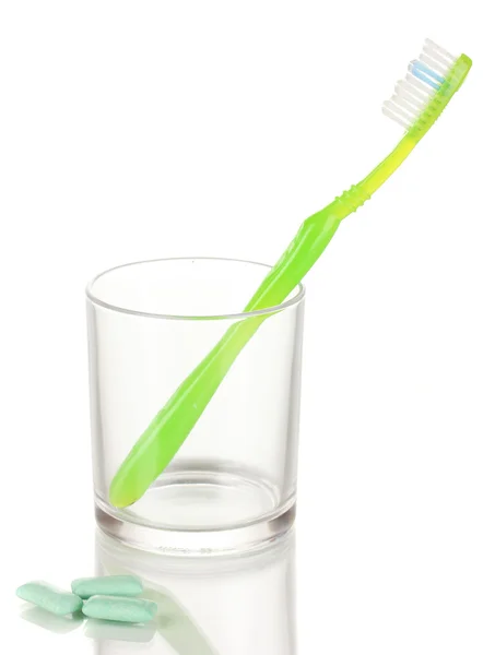 Cepillo de dientes en vidrio y goma de mascar aislada en blanco — Foto de Stock