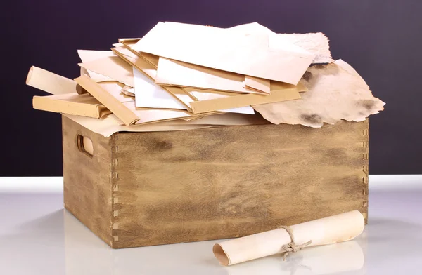 Dřevěná bedýnka s dokumenty a dopisy o fialovém pozadí — Stock fotografie