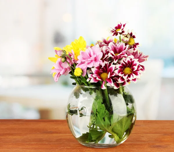 Colorido ramo de crisantemos en un jarrón de vidrio en la mesa de madera de cerca —  Fotos de Stock