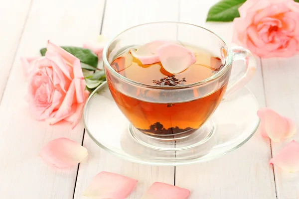 Ceașcă de ceai cu trandafiri pe masă albă din lemn — Fotografie, imagine de stoc