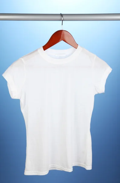Camiseta blanca en percha sobre fondo azul —  Fotos de Stock