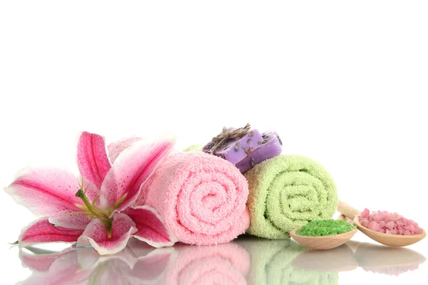 Toalhas com belo lírio rosa, óleo de aroma e sal marinho isolado em branco — Fotografia de Stock