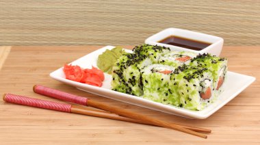 lezzetli rulo ile chopsticks açık renkli ahşap tablo üzerinde beyaz tabakta servis