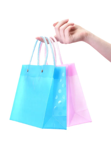 Mano femenina sosteniendo bolsas de compras brillantes aisladas en blanco —  Fotos de Stock