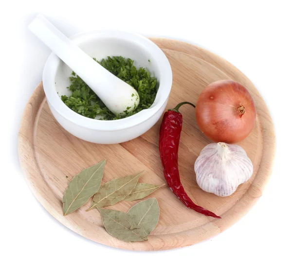 Composition of White mortar and pestle with vegetables and spice on cutting board isolated on white — Stock Photo, Image