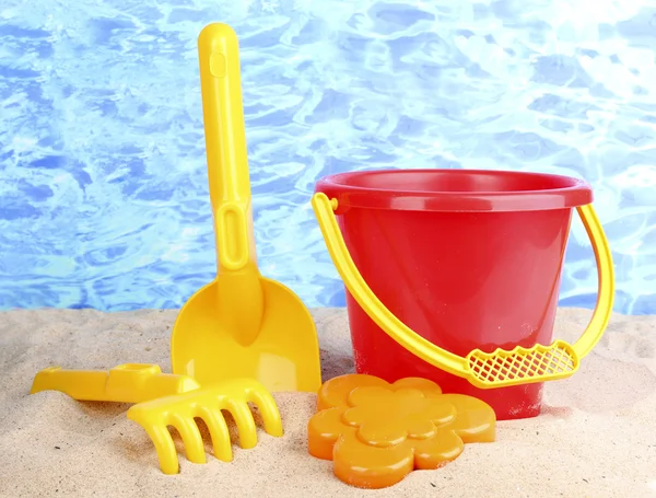 stock image Children's beach toys on sand on water background