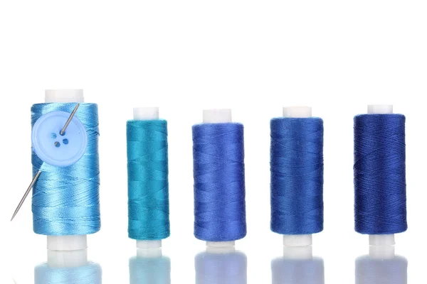 Muitos bobina azul com agulha e botões isolados em branco — Fotografia de Stock