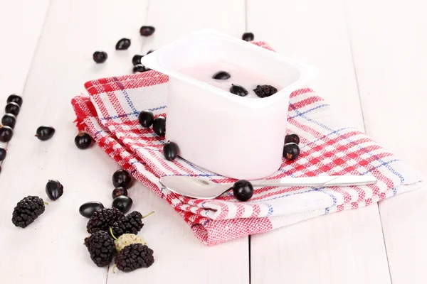 Yoghurt met bessen op houten achtergrond — Stockfoto