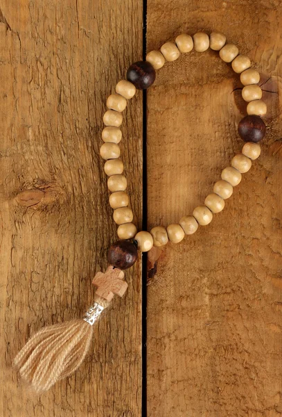 The Wooden rosary beads on wooden background close-up — Stock Photo, Image